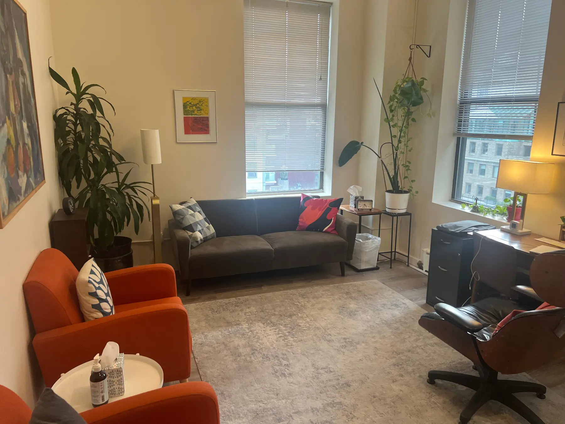 Jonathan Schnapp's psychotherapy office with a brown couch, orange chairs, and three windows